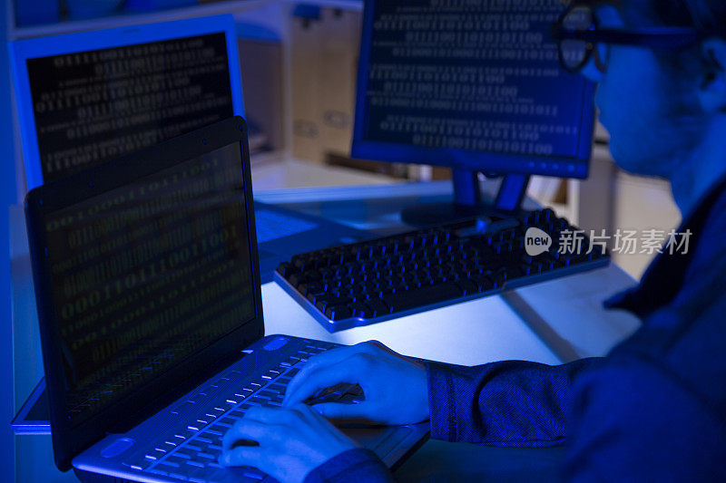 电脑黑客或程序员利用笔记本电脑进行网络攻击。