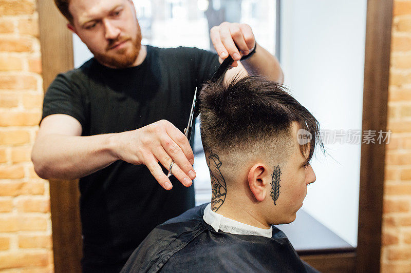 在理发店里剪时髦发型的男人。