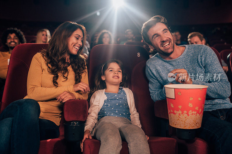 幸福的年轻家庭在电影院