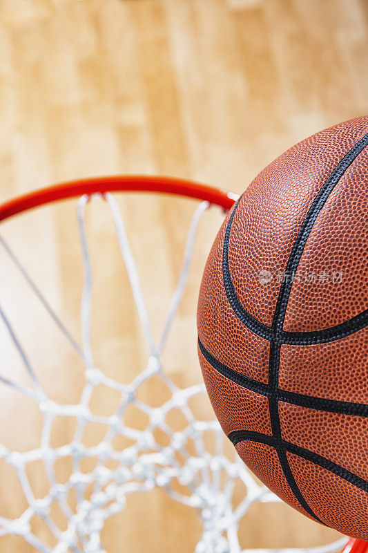 俯视着一个几乎在球馆木地板背景下的篮球网