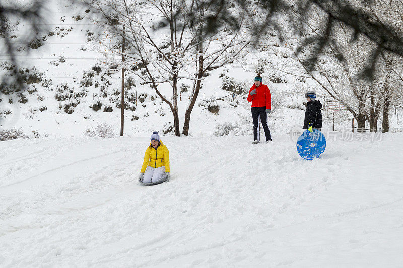 犹他州普罗沃市，一家人在暴风雪中从山上滑下，躲在树后