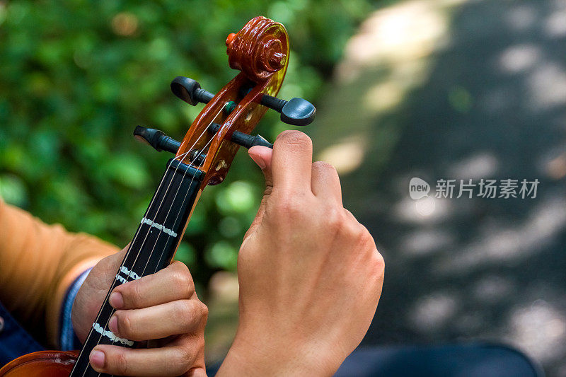 一个音乐学院的学生正在调他的小提琴