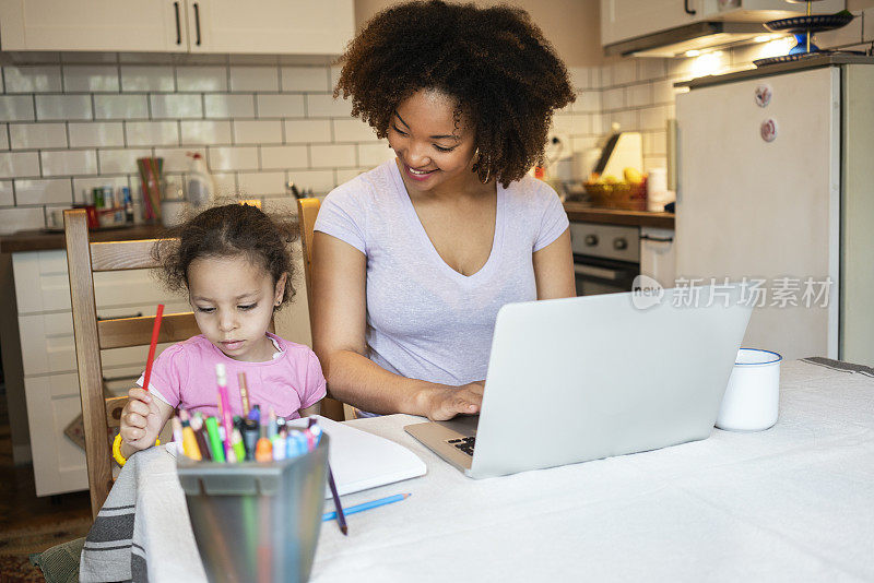 母亲和女儿在家里使用笔记本电脑
