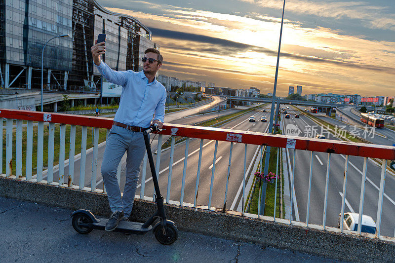 骑着电动滑板车在高速公路上的高架人行道上自拍