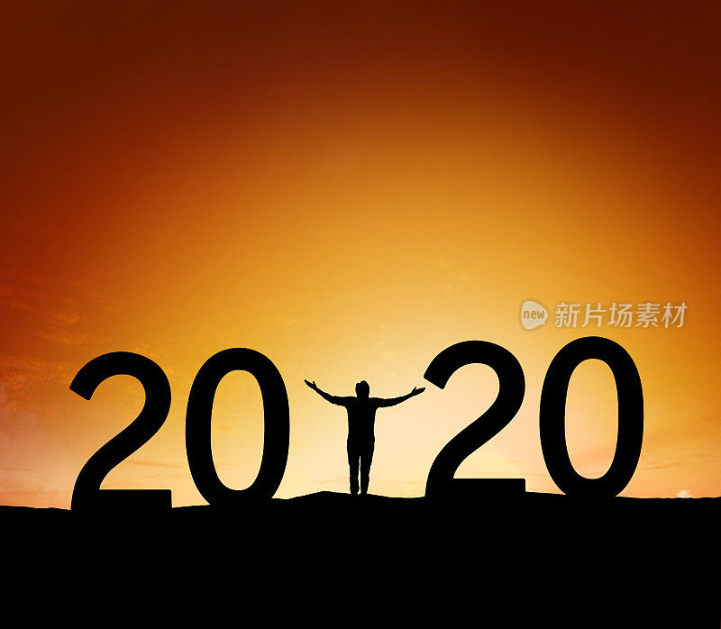 2020年，一个成功男人站在山上举手的剪影