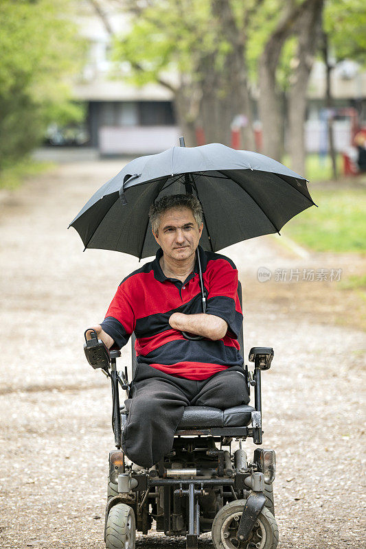 在雨天坐电动轮椅的残疾人在移动