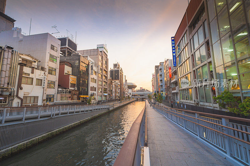在日本大阪的道顿堀，五颜六色的广告牌照亮了大阪夜市周围的商店和零售店