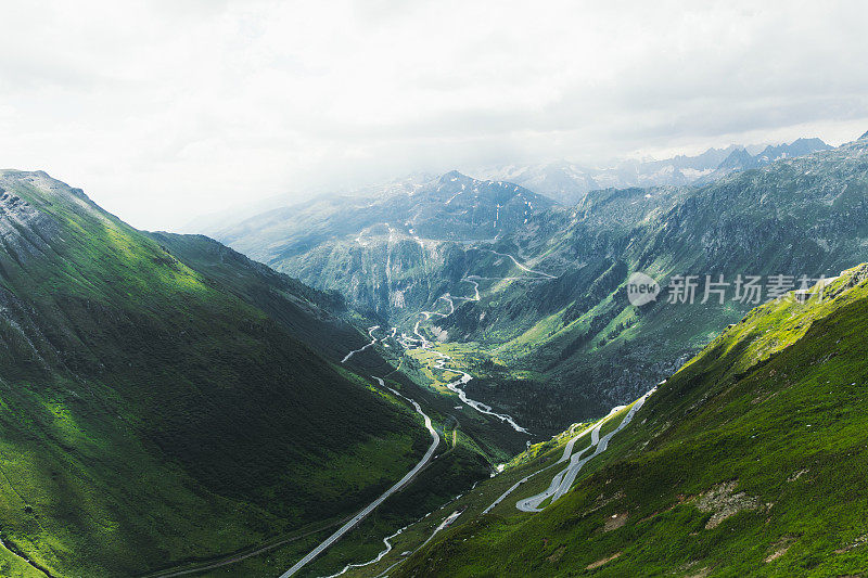 在阳光明媚的夏日里，瑞士弯弯曲曲的山路风景一览无遗