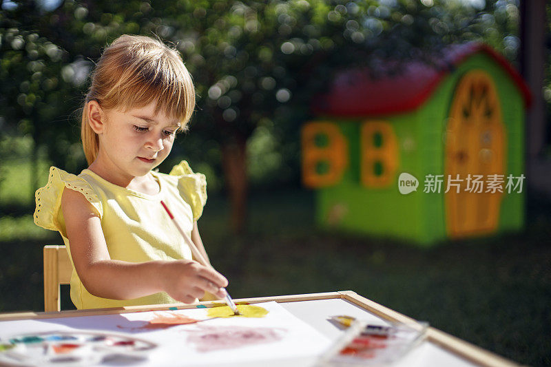 小女孩正在画一幅画