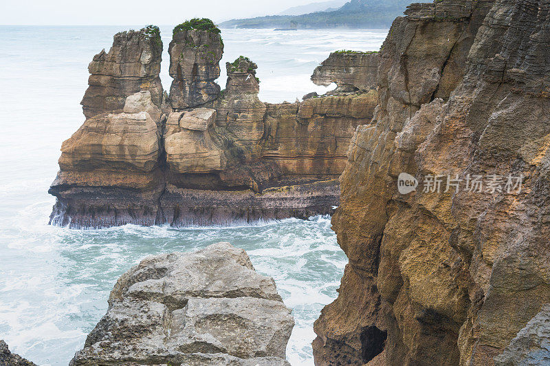 在新西兰南岛的西海岸Punakaiki，岩石周围的海景famaus煎饼岩石。