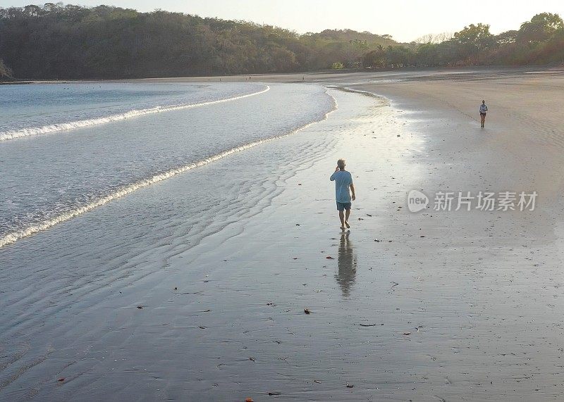 日出时，人们走在沙滩上