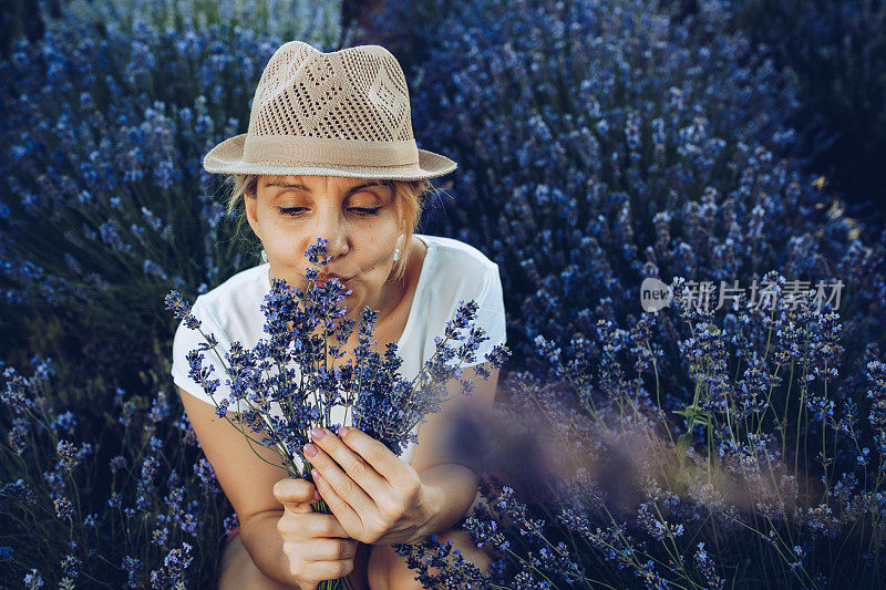 在薰衣草地里成熟的金发女郎。