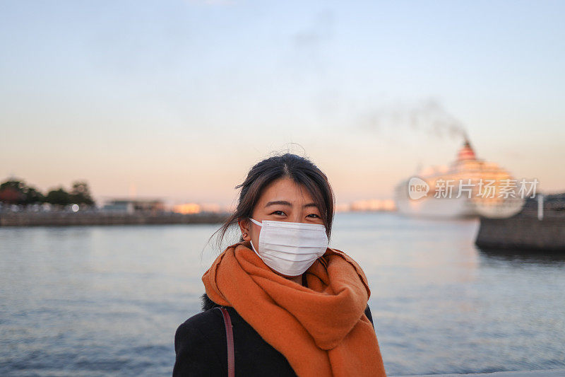 美丽的年轻女子放松在海港与面具