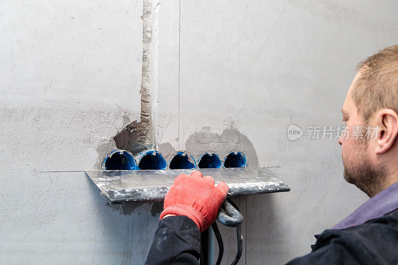 电工要把插座和电线的孔和槽抹上灰泥。