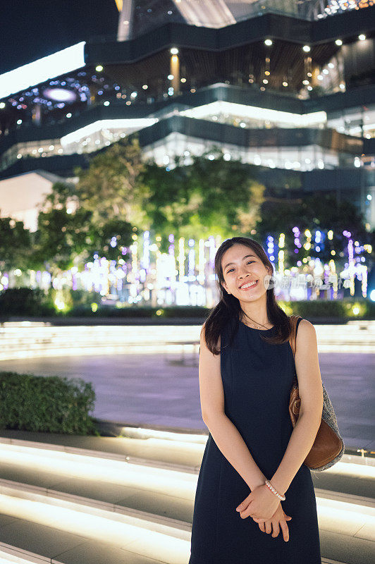 一个亚洲中国美丽的女人看着镜头微笑着愉快的情绪享受夜晚的时间