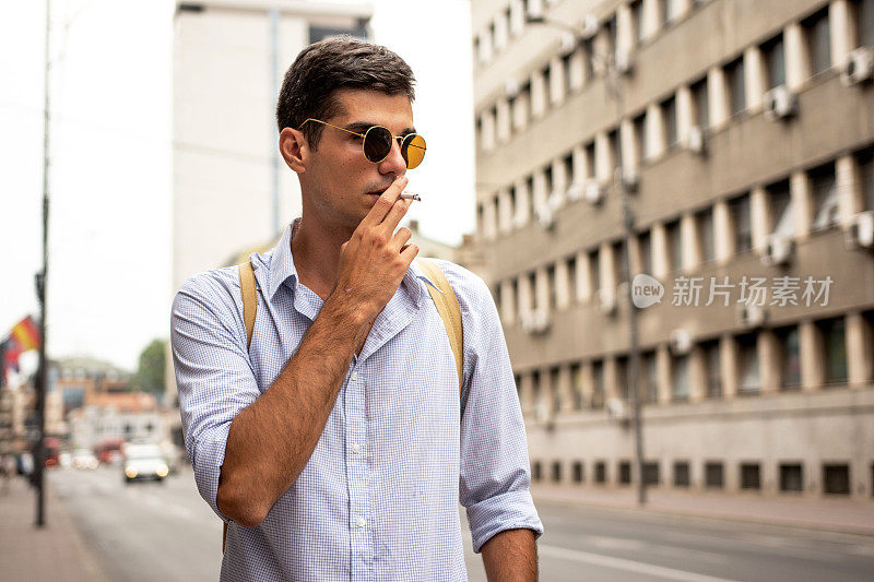 年轻人在城市的街道上抽烟