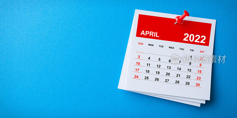 白色便利贴与2022年4月日历和红色图钉在蓝色背景