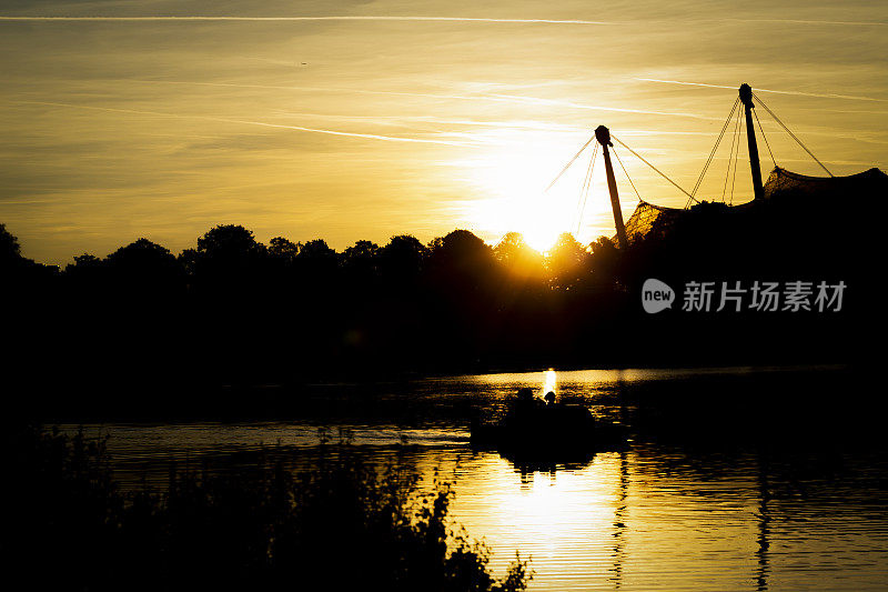 在一个秋天的傍晚，湖上的日落，一只船的剪影经过