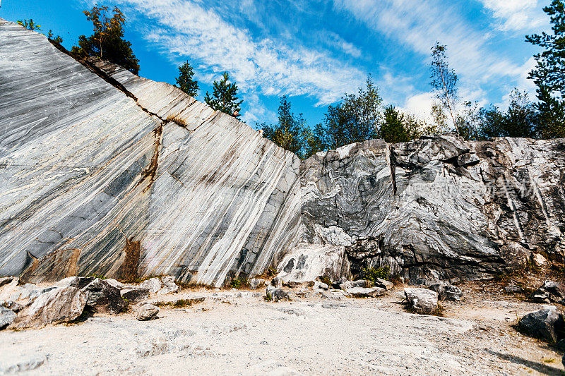 这块石头在自然环境中雕刻出未经处理的白色和灰色大理石表面。蓝色大理石的纹理