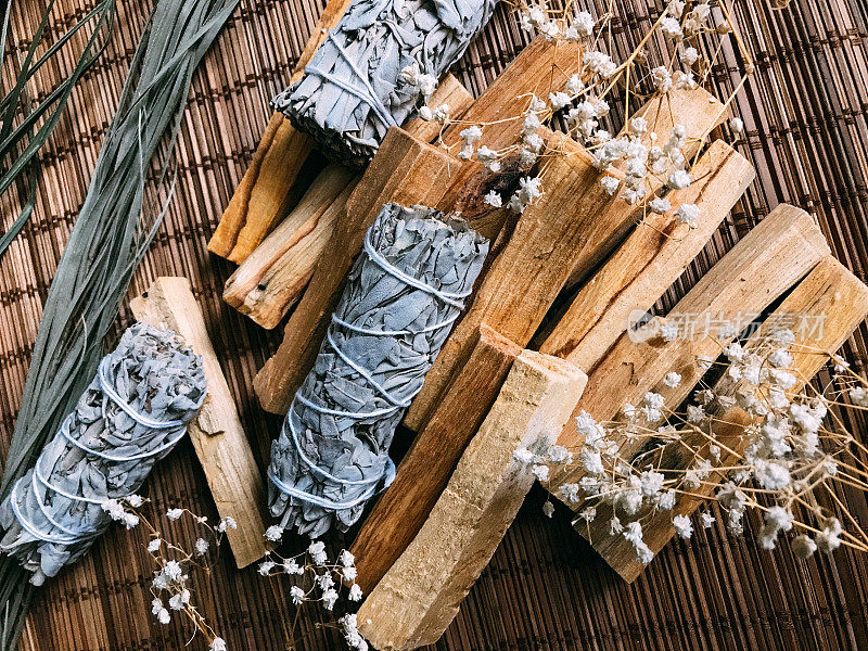 一个简单和美丽的背景，在竹子基质上的香精和香。特写微距拍摄的白鼠尾草和帕洛桑，有点模糊和模糊的焦点