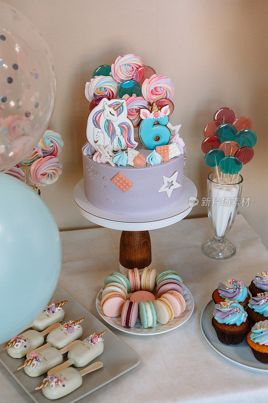 为庆祝生日而装饰的桌子上的蛋糕。气球、蛋糕、棒棒糖。六周年纪念日