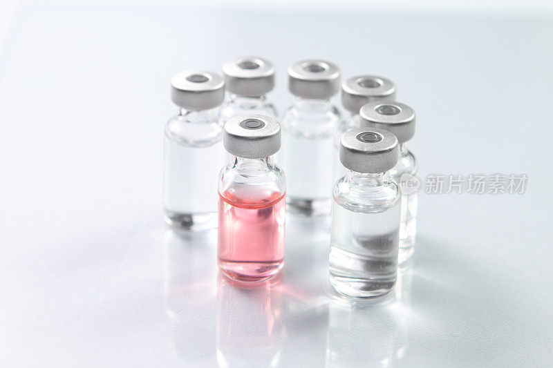 更好的药物粉红色的药物装在玻璃瓶里，周围环绕着不同的药物小瓶