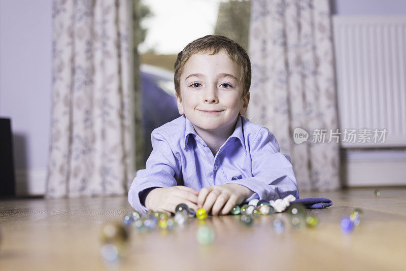 一个小男孩在玩弹珠