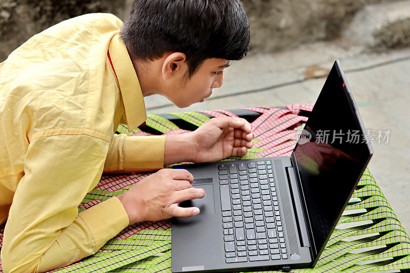 印度少年正在使用笔记本电脑