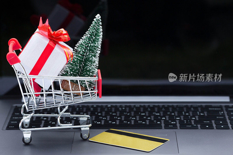 电脑，带礼品盒的篮子和信件。上面的英文铭文是:“sale”。圣诞网上商店。冬季假期销售，季节性销售，黑色星期五，圣诞节，折扣和现场购物