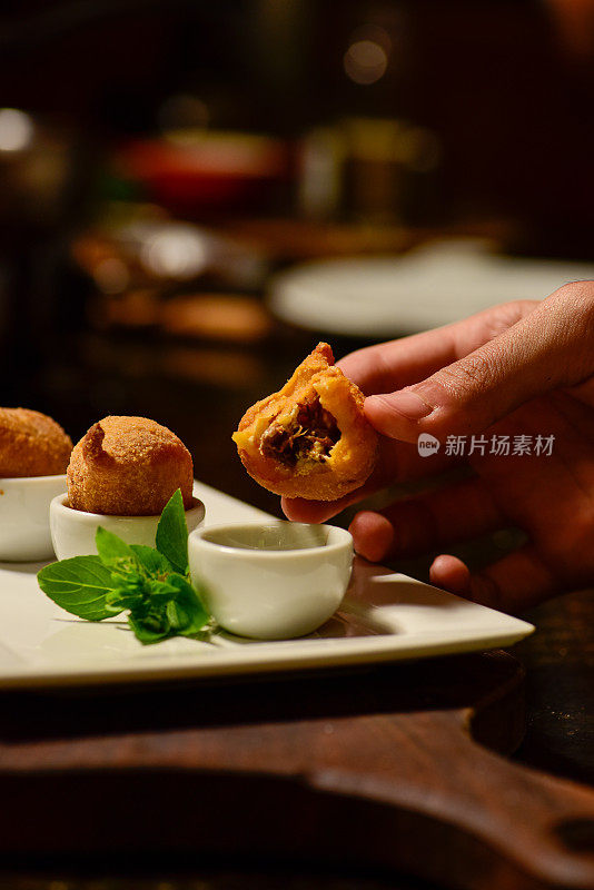 端上新鲜食物的人。Coxinha零食。有机巴西食品