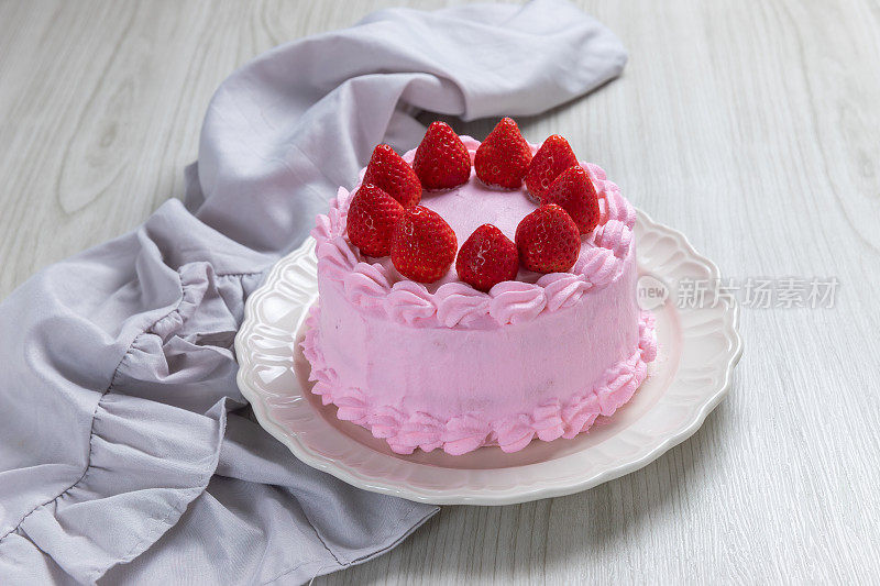 草莓蛋糕，草莓海绵蛋糕与新鲜的草莓和鲜奶油在木制背景。
