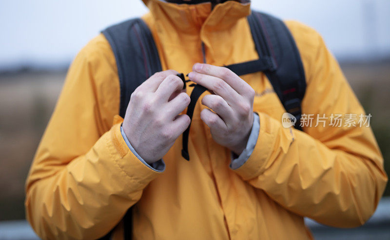 徒步旅行的人带着防水雨衣和背包