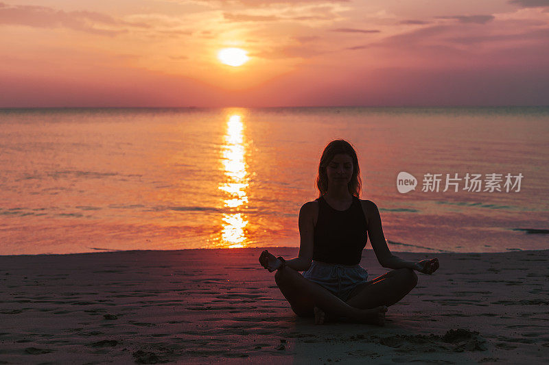 瑜伽和冥想平静宁静的海滩日落适合年轻女子