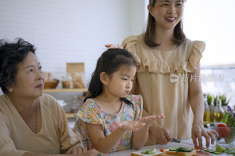 奶奶、妈妈和孙女在厨房准备食物。