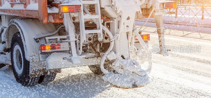 高速公路上的扫雪机。橙色卡车除冰街道。保养冬季磨砂车。