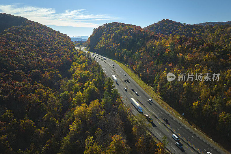 金秋时节，北卡罗莱纳州的I-40高速公路穿过阿巴拉契亚山脉，通往阿什维尔，沿途有快速行驶的卡车和汽车。州际运输概念