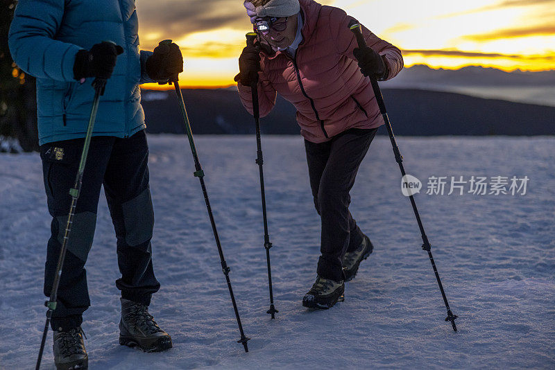 老妇人和丈夫在雪山上徒步旅行时筋疲力尽