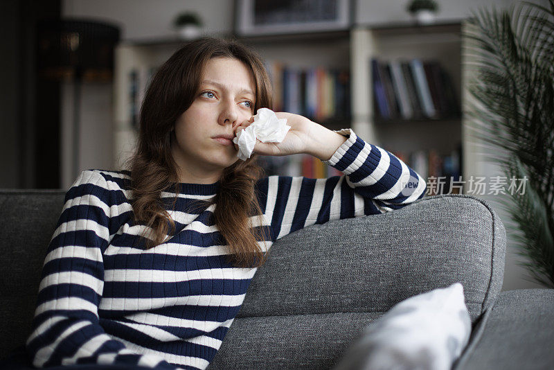 年轻女子坐在沙发上哭