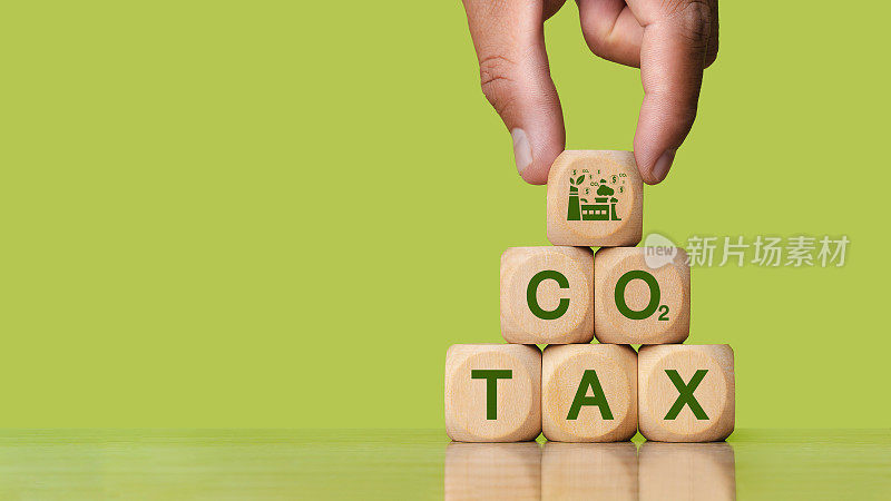 绿色二氧化碳税的概念，碳税，环境和社会责任。自然污染税收污染控制木块绿色背景上写着二氧化碳税