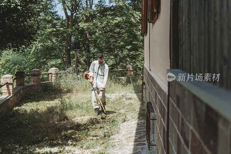 一个年轻人在给花园除草