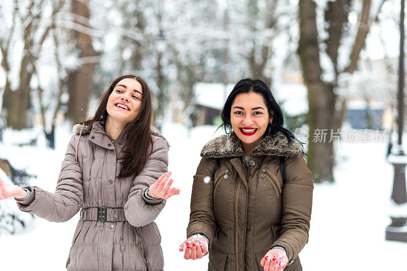 快乐的妈妈和女儿在雪中玩耍