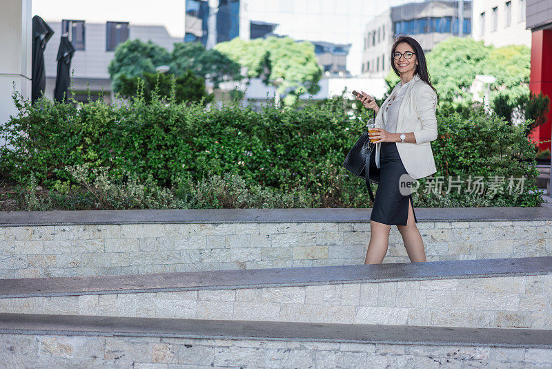 女商人在户外用手机发短信