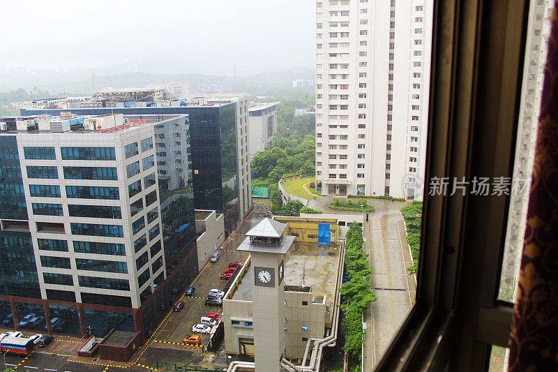 窗外是孟买，窗外是远处的办公楼、公寓、道路和青山