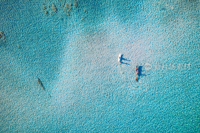 在碧绿的海水中划皮艇。皮划艇，海上休闲活动。无人机鸟瞰皮艇巡航在热带海景绿松石和蓝宝石清澈的水域。