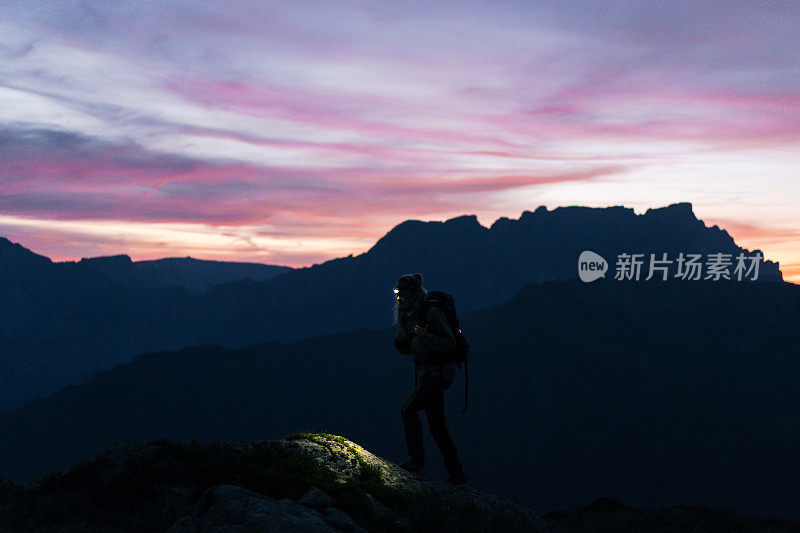 日出时，女徒步旅行者穿过山脊