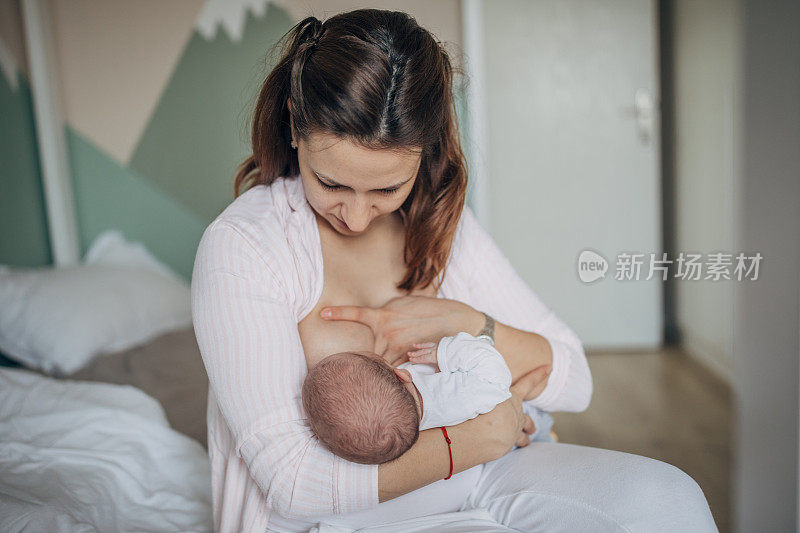 母亲在家里母乳喂养她的男婴