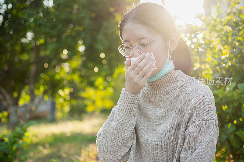 年轻的亚洲青少年戴上防护口罩以防止冠状病毒的传播，并搬到她的家里进行隔离。全球突发卫生事件Covid-19