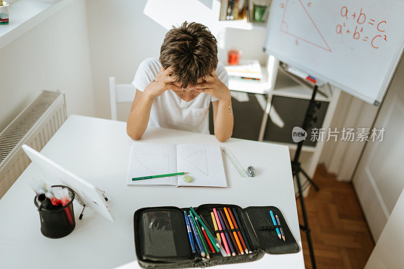 在线课堂上不开心的男孩。在COVID-19大流行期间返回学校