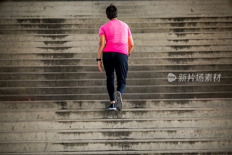 肌肉发达的运动员跑上楼梯。早上锻炼。城市场景。健身、运动、娱乐、锻炼、健康的生活方式理念。