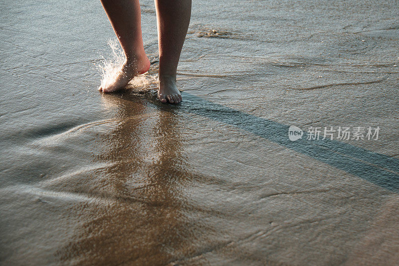 一个女人在海滩上散步的细节